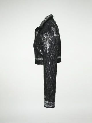 A side view of a black and silver distressed cotton waist-length jacket with overlays of sequins, black lace, metallic embossed leather, and black leather.