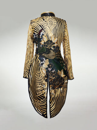 The back of a long gold and black tailcoat. The base is black with gold swirling leather strips on top. A large antique embroidered peacock stretches across the back with gold and green flowers.
