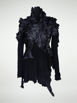 A black gathered silk jacket with irregular draping.