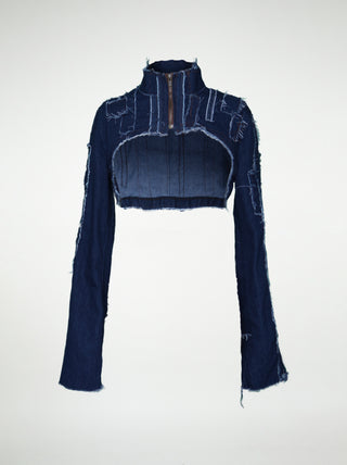 The front of a women's blue denim over-bust shrug with long sleeves and raw edge patchwork.