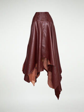 A front view of a maxi-skirt with an asymmetrical hemline, made of oxblood leather, featuring a metal zipper closure at the back.