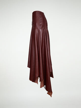 A side view of a maxi-skirt with an asymmetrical hemline, made of oxblood leather, featuring a metal zipper closure at the back.