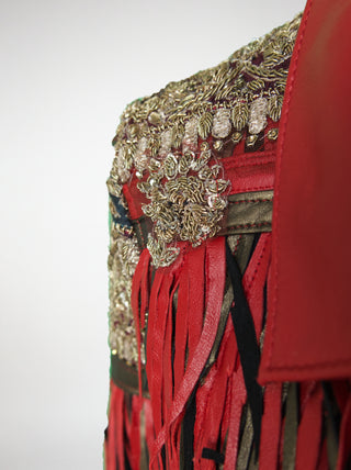 Close-up of a red and bronze jacket with fringes on a white background
