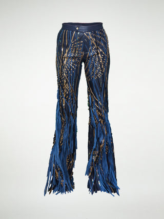 A pair of blue flared trousers with leather embellishments and fringes, displayed against a white background.