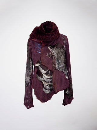 A burgundy lamb shearling coat with antique embroidered cranes and lace appliques, featuring metal snap closure.