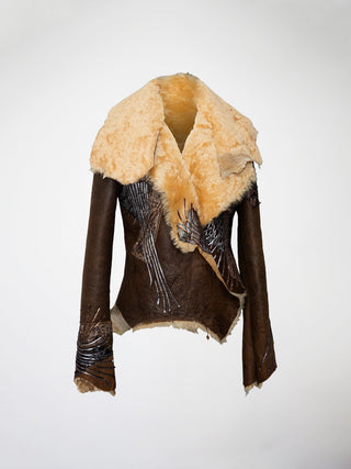 A brown and blond shearling jacket with leather and embroidered appliqué.