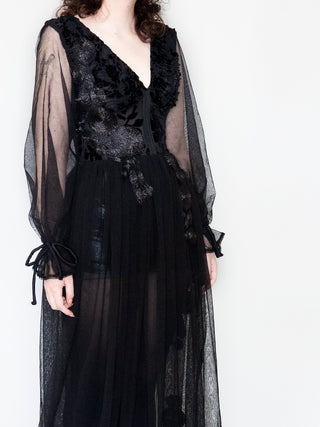 Close up of black gown with french lace, shear sleeves, and corseted midriff.