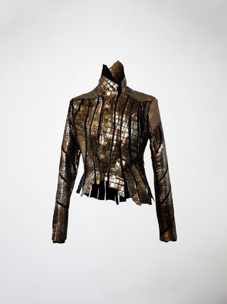 A bladed leather jacket with metallic gold and brown panels, featuring an asymmetrical hem and collar, and large metal snap closure.