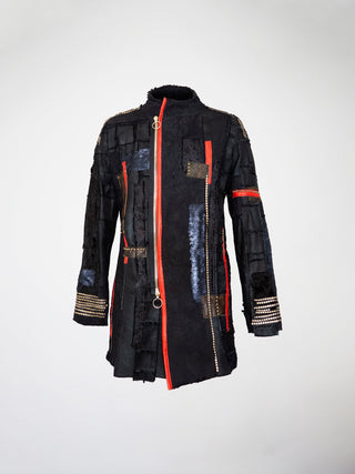 A black cotton jacket with red and camo-print leather strips, embossed lamb leather, sequins, and metal studs, featuring a distressed military style.