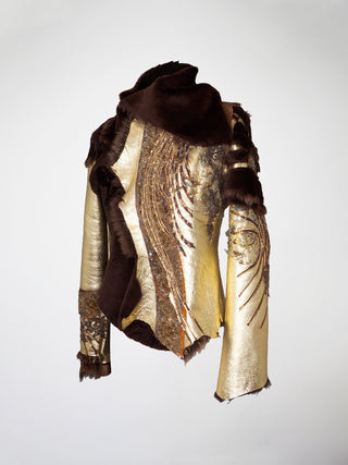 A gold and brown shearling jacket with lace appliqué.