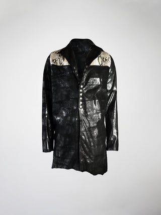 A long black leather jacket with panels of cream snake-print leather on the shoulders and a metal snap closure.