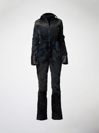 A hand-dyed green corduroy jumpsuit with long sleeves and a zipper down the front.