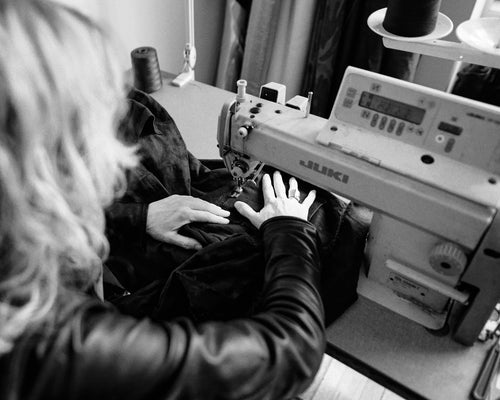Person using a sewing machine with a close-up of hands and machine details.