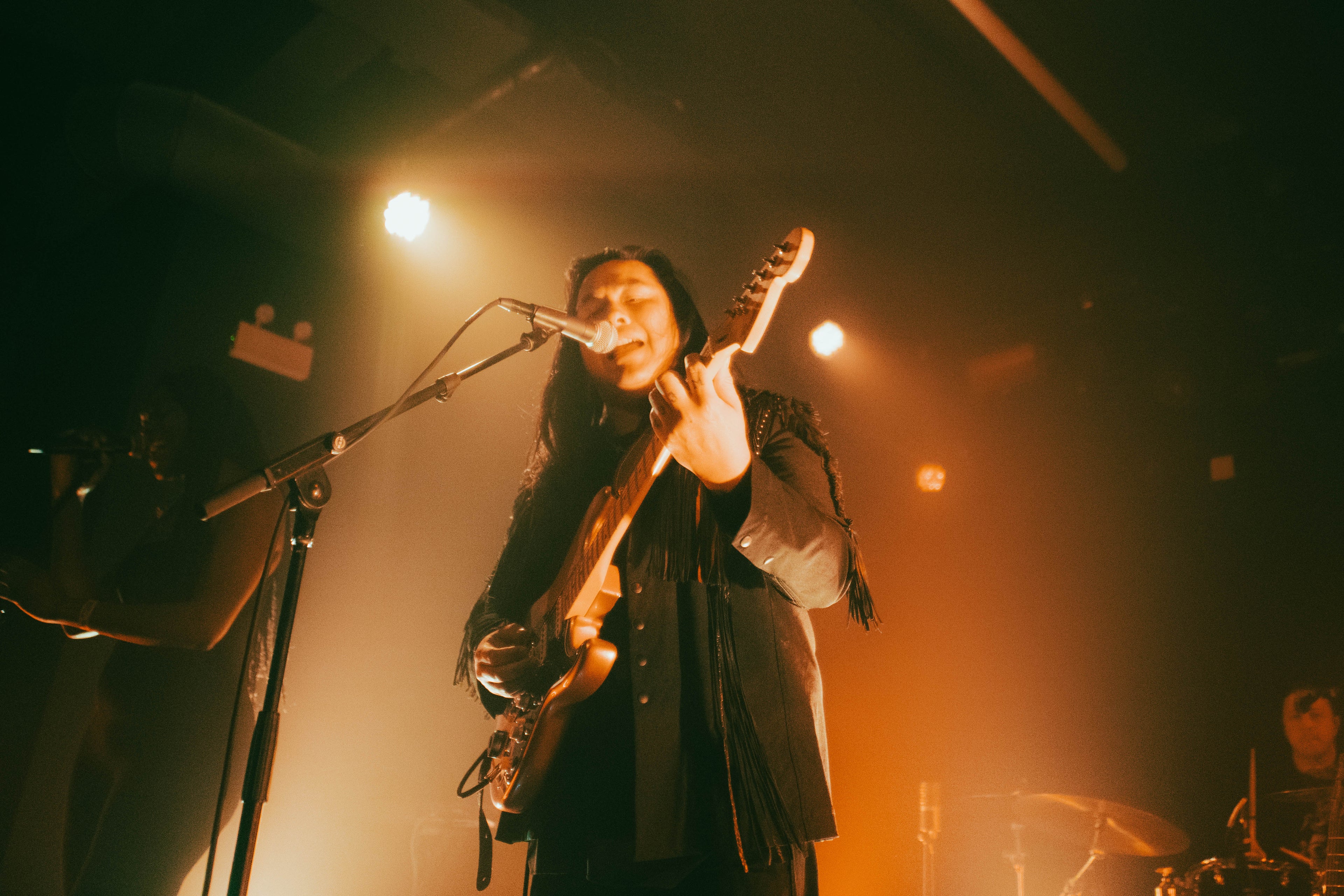 Aysanabee wearing a call and response jacket while performing