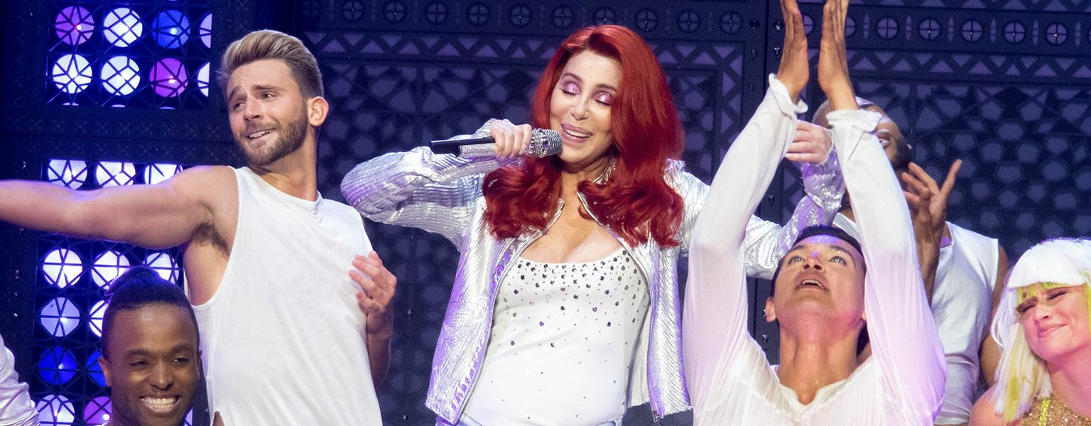Cher on stage during her Here We Go Again tour wearing a call and response jacket