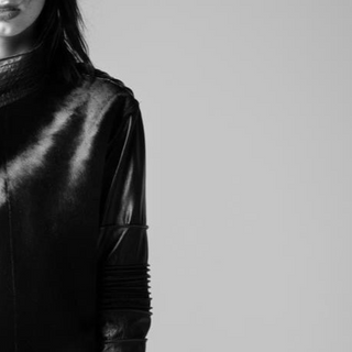 Black leather outfit with long sleeves on a plain background