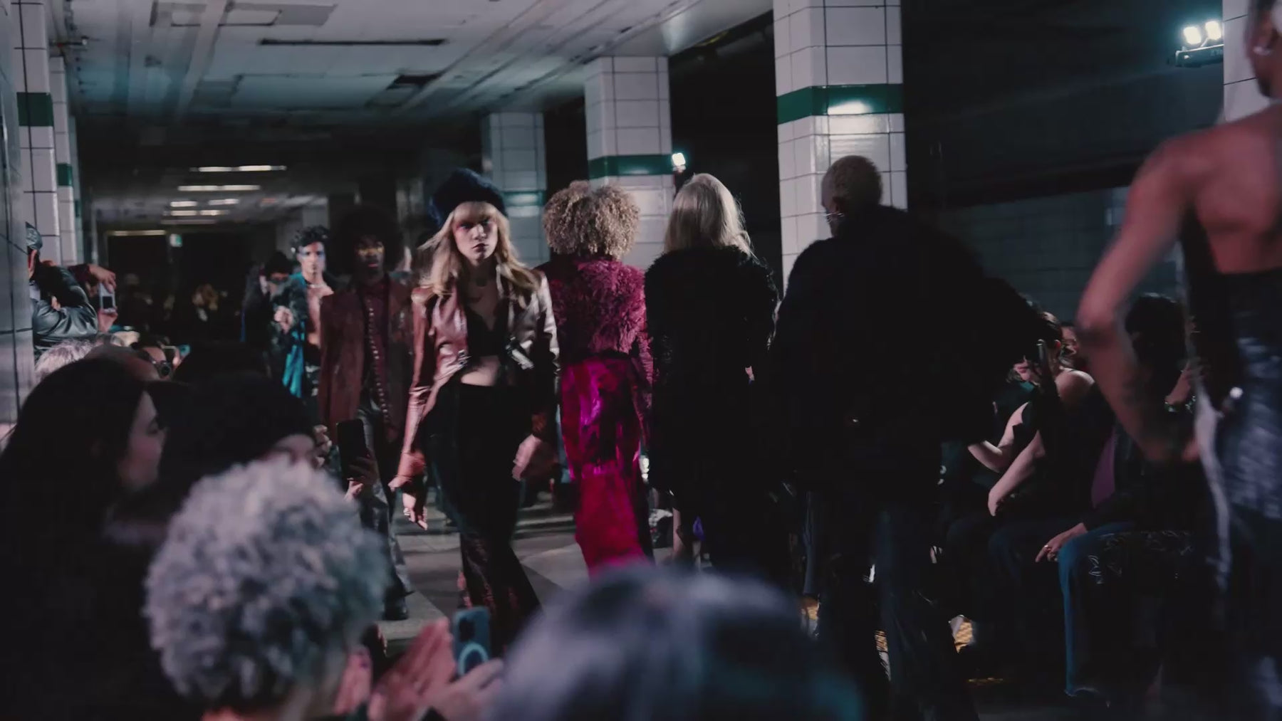 Models walk down a runway in a subway station wearing the AW 25/26 collection