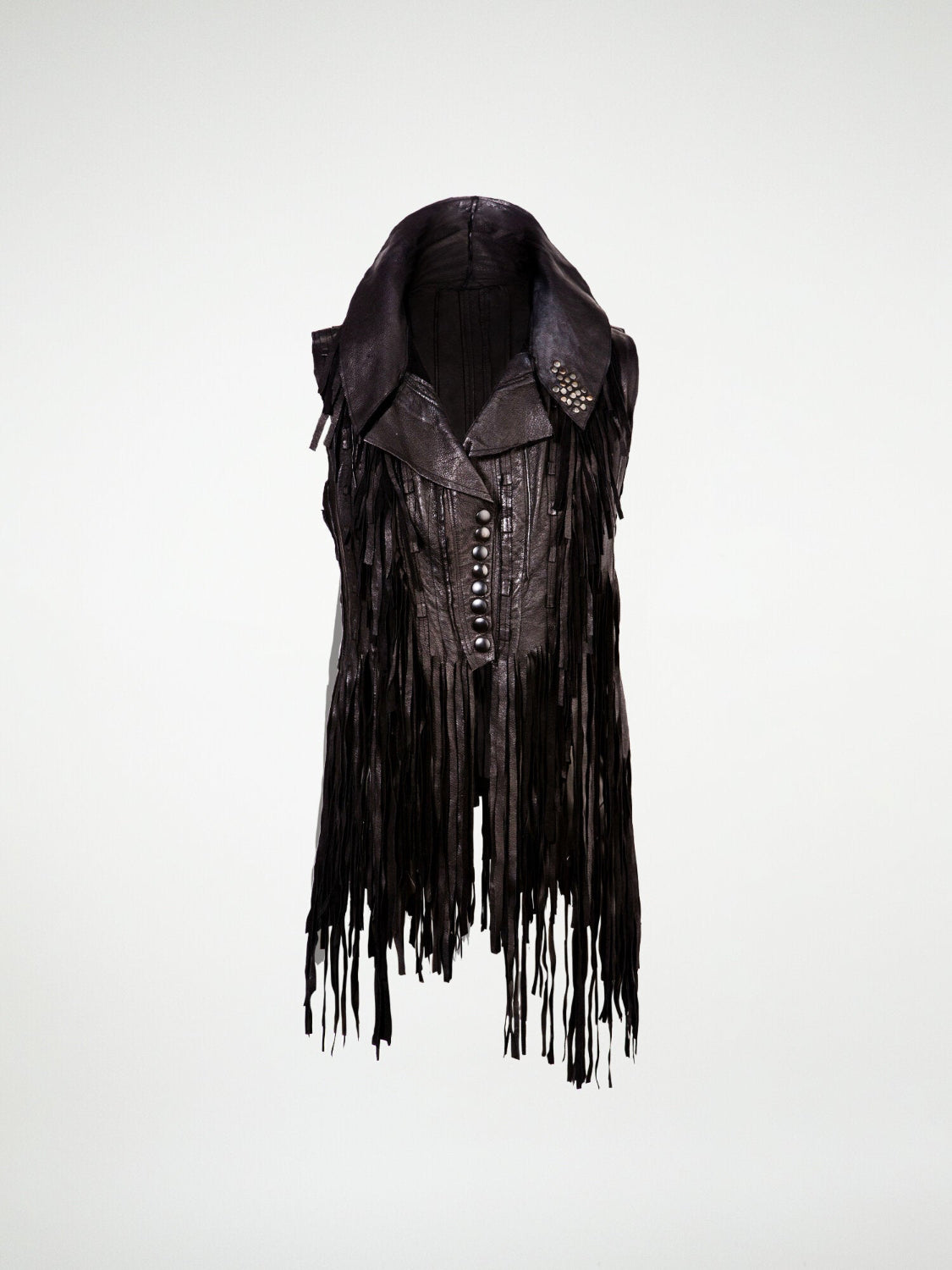 A black biker vest with textured leather strips and hand-cut fringes, embellished with metal stud details.