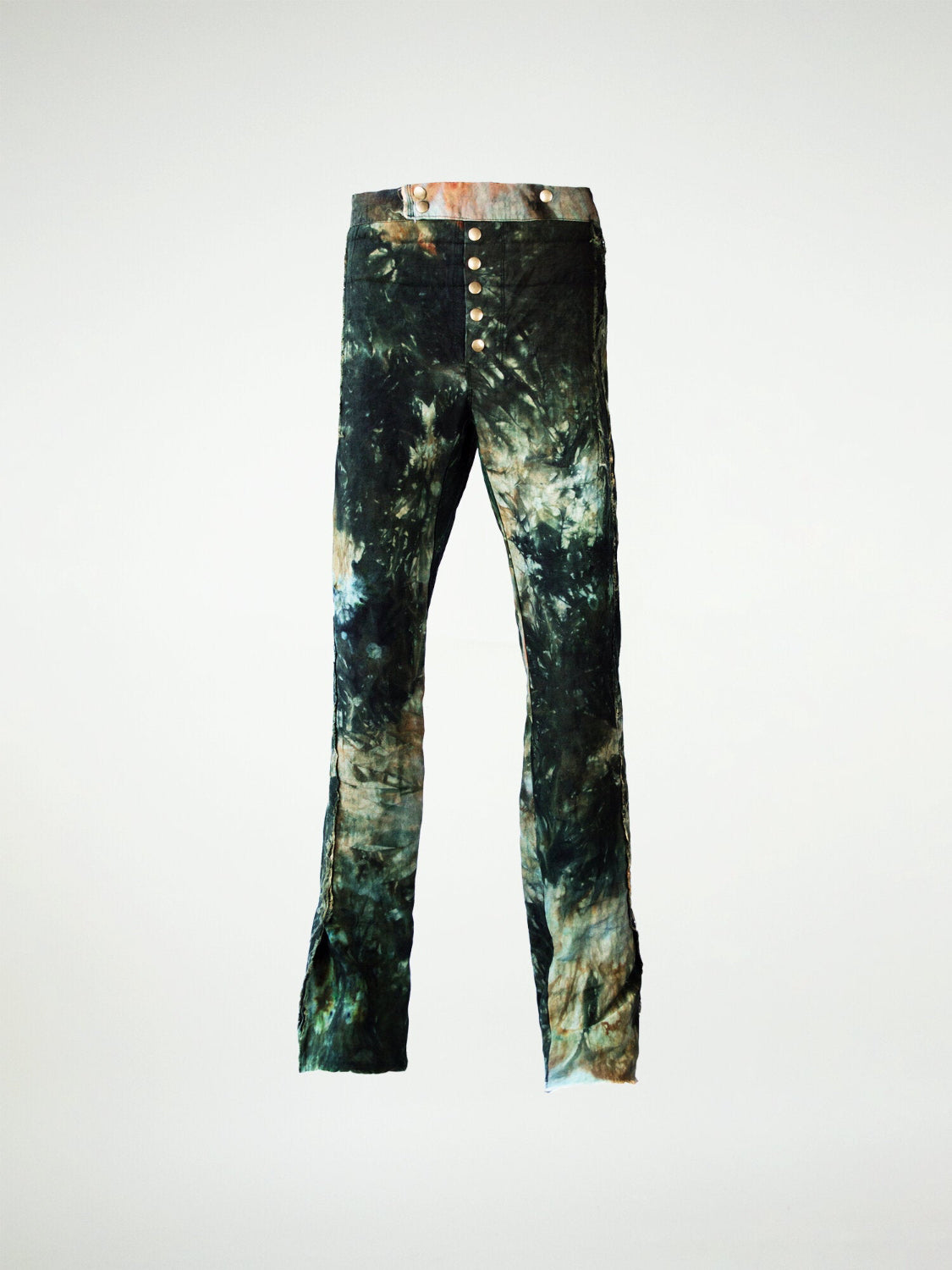 A pair of hand-dyed linen trousers with a tie-dye pattern in various shades of green and a metal snap fly closure.