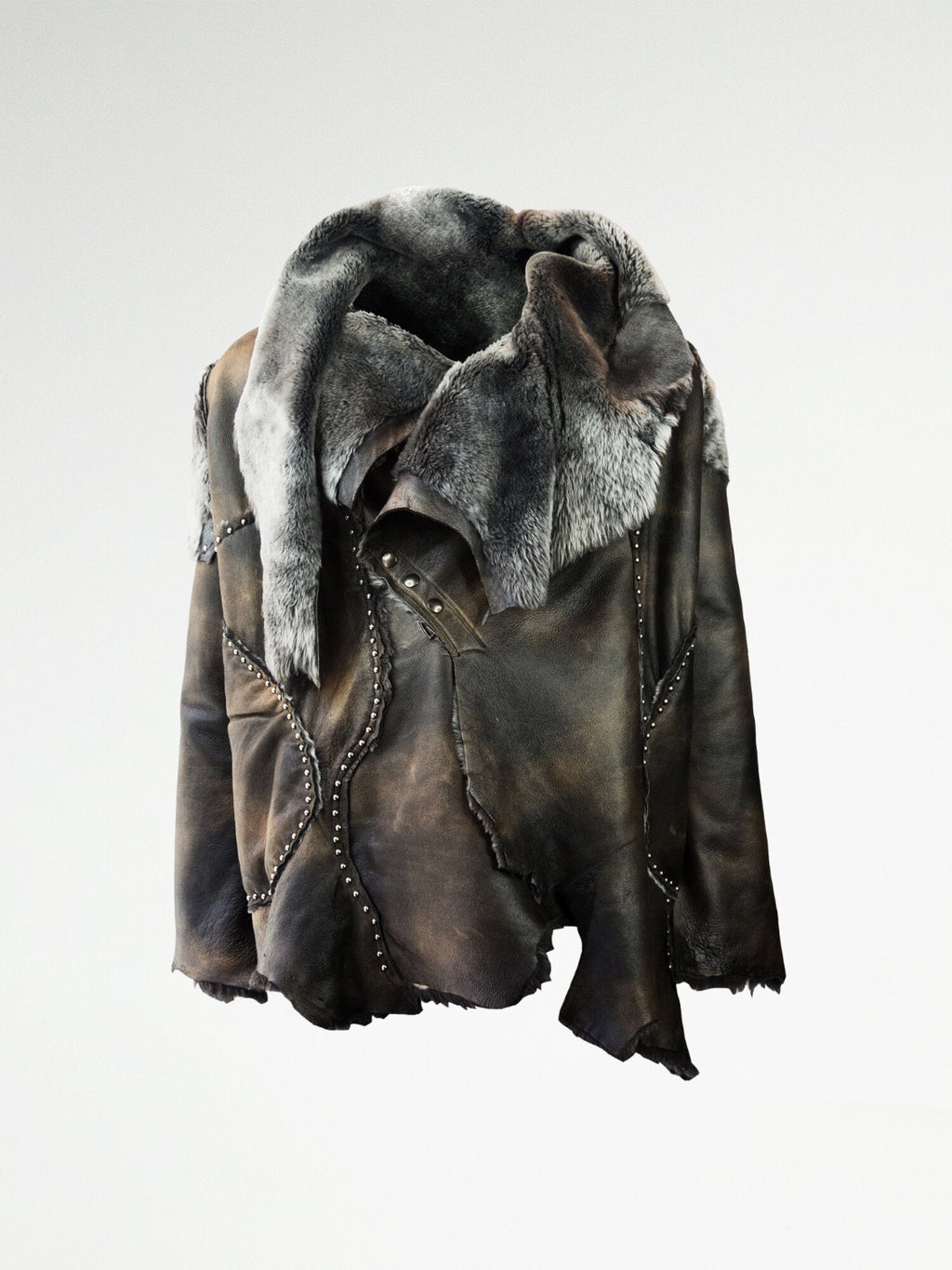 A luxurious shearling coat with metal stud embellishments and a metal snap closure, featuring metal studding along the irregular seams.