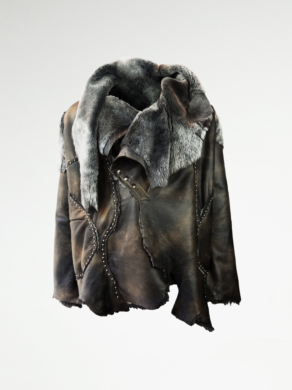 A luxurious shearling coat with metal stud embellishments and a metal snap closure, featuring metal studding along the irregular seams.
